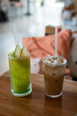 There are two drinks placed on a wooden table in front of you