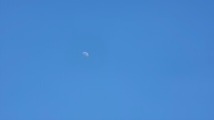 Clear blue sky with afternoon moon, green forest mountains, and peaceful nature scenes captured in South Korea
