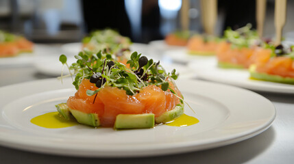 Artfully arranged tartare of salmon and avocado with microgreens and citrus oil.