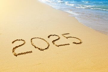 New year 2025 written on sand