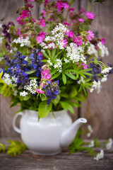 Bouquet of colorful wildflowers on an old wooden background. Still life with wild flowers