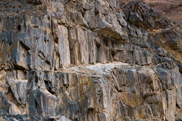 Rugged sedimentary rock formation in Kyrgyzstan mountains during daytime