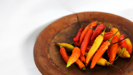Colorful Chili Peppers on Clay Plate with White Background