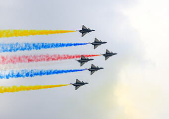 J-10 Acrobatic airshow team from China Air Force on formations with colorful smokes venting from the plane.