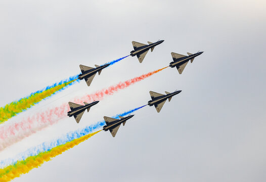 J-10 Acrobatic airshow team from China Air Force on formations with colorful smokes venting from the plane.