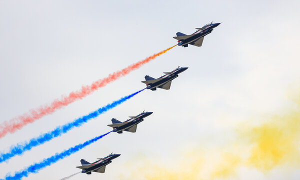 J-10 Acrobatic airshow team from China Air Force on formations with colorful smokes venting from the plane. - Powered by Adobe