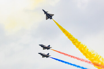 J-10 Acrobatic airshow team from China Air Force on formations with colorful smokes venting from the plane.