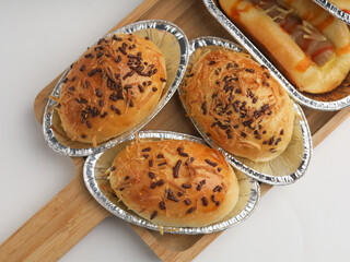 Sweet breads in aluminum foil on wooden tray