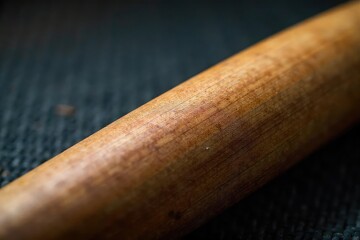 Close-up of worn baseball bat, grain texture visible, background, vintage, close-up