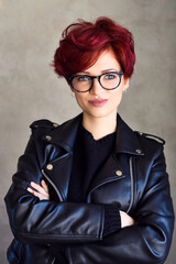 Portrait of a beautiful young red-haired woman wearing elegant glasses. Optics style