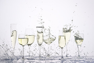 Set of wineglasses with splashing white wine
