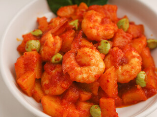 Stir fried shrimp and potato cooked in chilies in white bowl