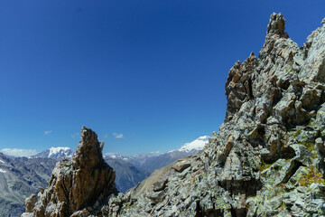 Fototapeta premium Stunning rocky formations tower over the breathtaking landscape of the Andes mountains under a vibrant blue sky, showcasing the beauty of nature on a clear sunny day