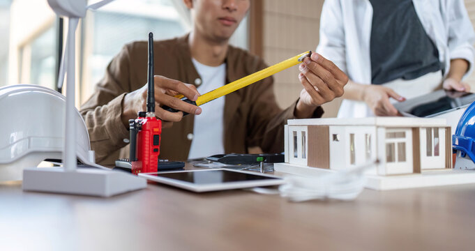 Measuring for Sustainability. Architect using tools for eco-friendly building design.