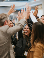 Group celebrates success with high fives, feeling joyful and accomplished