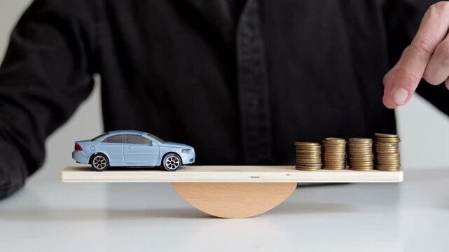 Toy car and coins on wooden balancing scale. The concept of saving money for a future car purchase.