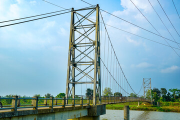 view from the iron suspension bridge crossing the river with a clear sky background for advertising space.
