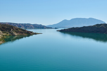 Peaceful Blue Lake Surrounded by Hills and Mountains on a Sunny Day