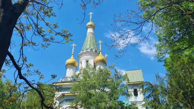 Picturesque shot of the Church of St. Nicholas the Miracle-Maker in central Sofia, Bulgaria, on a bright and sunny spring day, surrounded by vibrant green foliage