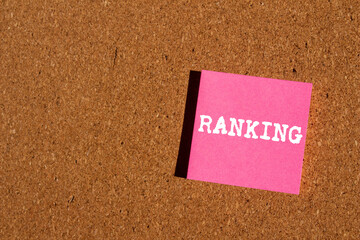 Ranking message written on pink paper sticker on brown background. Conceptual ranking symbol. Copy...
