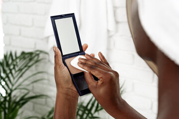 Applying foundation in a modern bathroom with natural elements and soft lighting