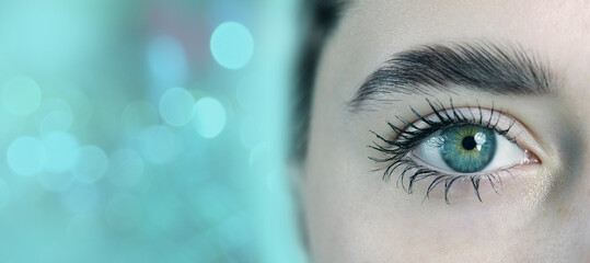 Close-up of a captivating eye with striking colors situated against a blurred turquoise backdrop