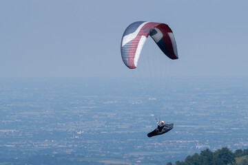 Paraglider flies in the air -Aerial view of paraglider above the mountains
