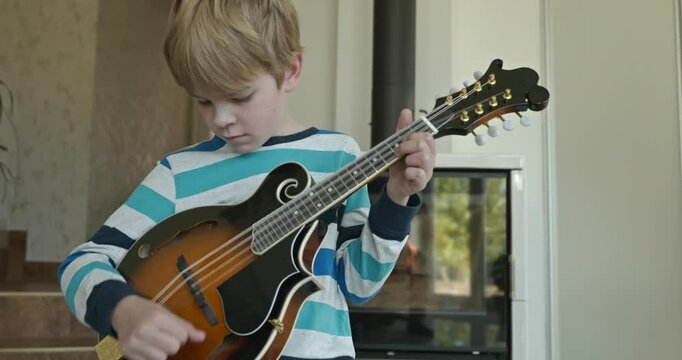 Caucasian Kid Play Mandolin at Home. European Boy Practice Music 4K 10-bit