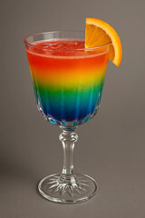 Colorful rainbow cocktail with orange slice	