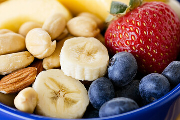Healthy snack bowl with nuts and fresh fruit close-up