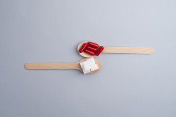 Diabetes concept. Pills, spoon of sugar on light background. Threat of diabetes. Health concept.