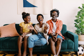 Plakat Happy family enjoying a football game together at home