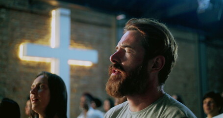 Bearded man deeply immersed in prayer during spiritual worship, emotional and reflective moment of...