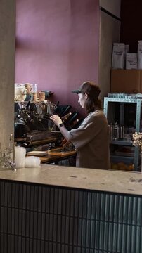 barista girl stands behind the counter at coffee