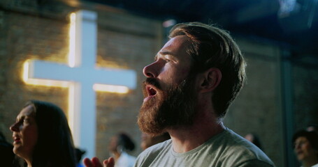 Bearded man deeply immersed in prayer during spiritual worship, emotional and reflective moment of...