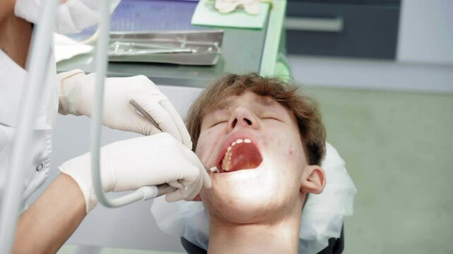 Teenager undergoes dental procedures in a bright clinic with professionals attending to oral health needs