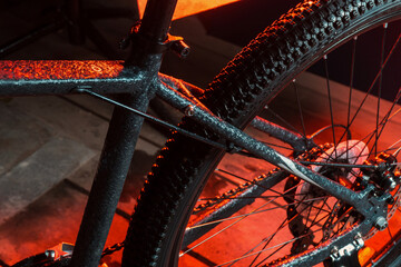 new dark gray bike for teenagers with gear shifting and disc brakes indoors illuminated with red...