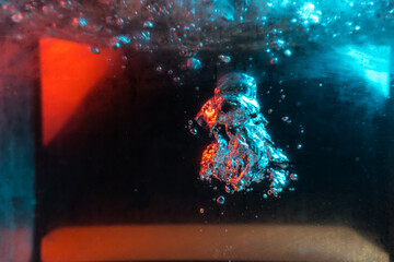 water texture rumbling chaos with bubbles created by air escaping outside in blue and red light