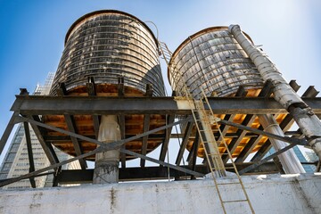Rooftop wooden water tanks in urban setting.