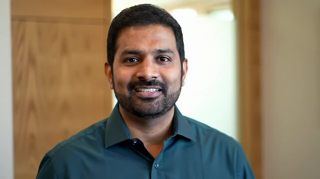 Close up of a Man in Green Shirt Speaking Directly to Camera in Soft Lighting