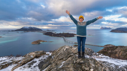 hiking woman on hill, winter nature of Norway. Hiking by the fjord and mountains on the island of...