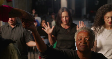 Obraz premium Elderly woman holding hands with spiritual leader during prayer in church, expression of faith and connection, diverse congregation praying in unity in the background