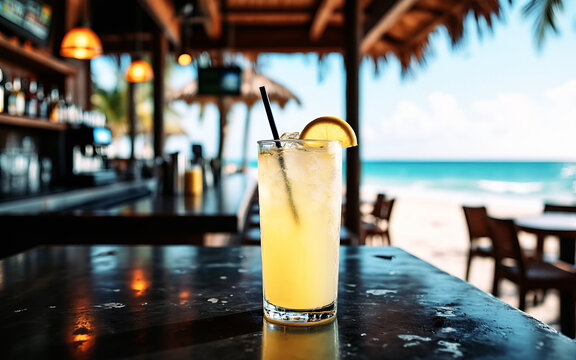 bicchiere di limonata ghiacciata in primo piano su un tavolo da bar, sfondo con locale all'aperto su una spiaggia assolata