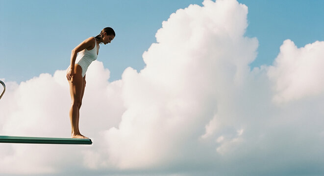 Woman in White Swimsuit on Diving Board Against Cloudy Sky