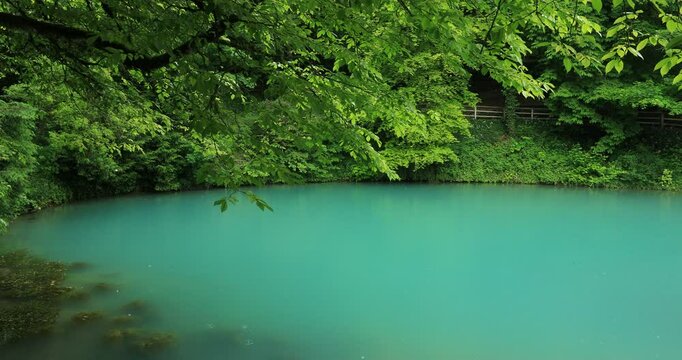 Magischer Blautopf im Regen mit t&uuml;rkisblauem Schimmer