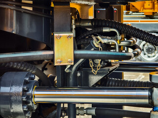 Close-up view of hydraulic system components on construction machinery at a work site