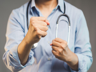 Confident female doctor in blue shirt showing clenched fists symbolizing healthcare strength.