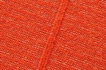Red purl wool jersey fabric texture with a seam in the center as background