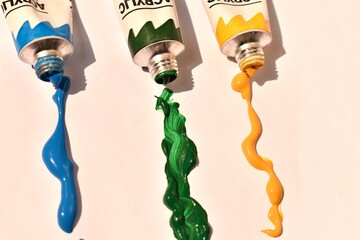 Open acrylic paint tubes with colorful paint spilled around. Creative mess full of vivid color and inspiration.

