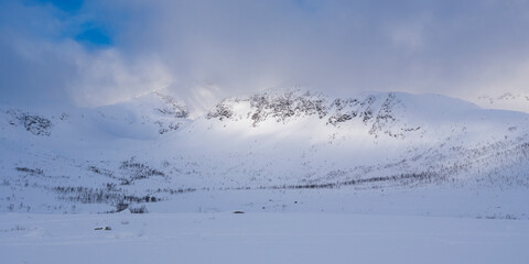 illuminated rocky mountains in the glacier-made valley, snow-covered landscape in solitude,...